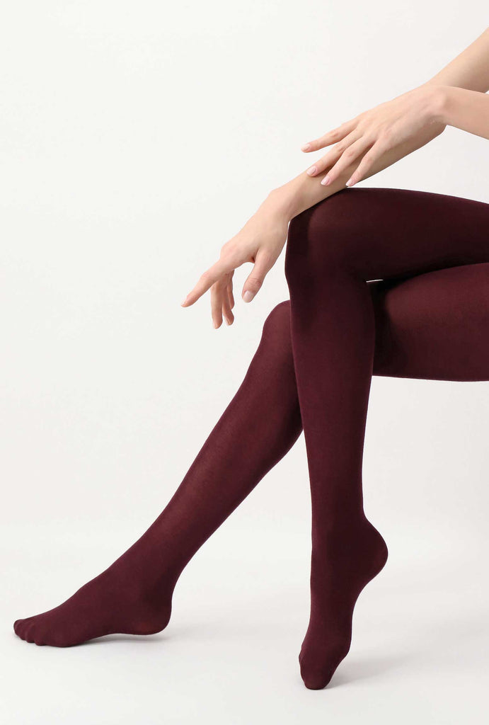 side view of lady's legs crossed at the knee, wearing dark red tights.
