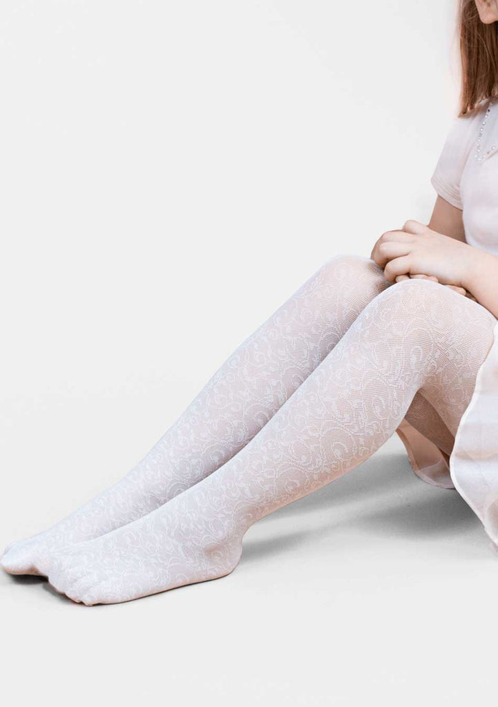 Outstretched legs of a young girl in white flower tights and no shoes.