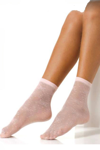 Bottom half of a girls legs extended wearing pink tulle socks with butterfly pattern.