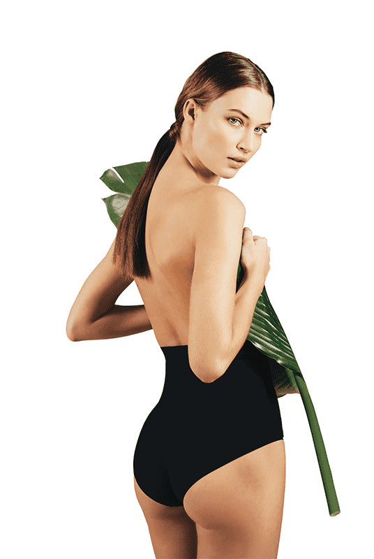 Back view of lady in black high waisted briefs  with large leaf covering her front body.