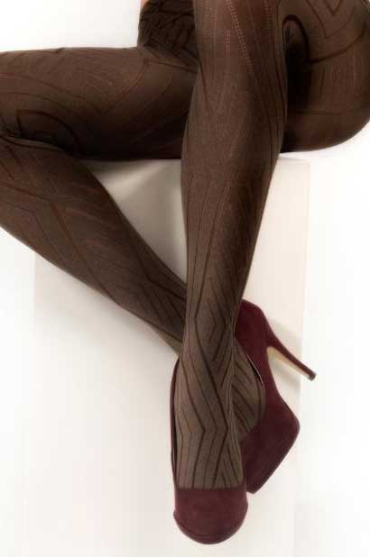 Close up of lady's legs crossed at the ankles wearing brown pattern tights and red heels.