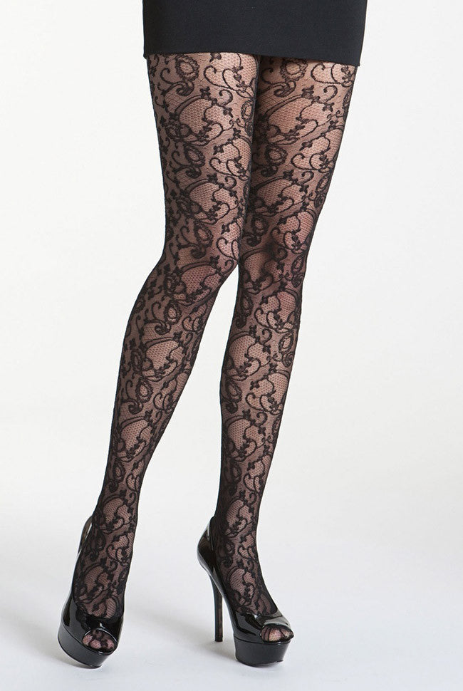 Ladies legs in black floral lace tights, black heels and skirt.