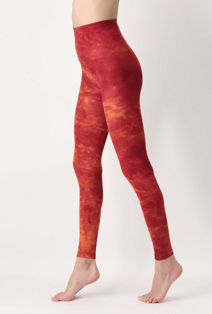 Side view of lady's legs in red, orange tie-dye leggings.