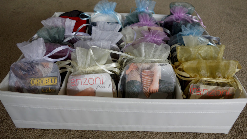 Calico box filled with tights and socks displayed in rows within transparent tulle bags