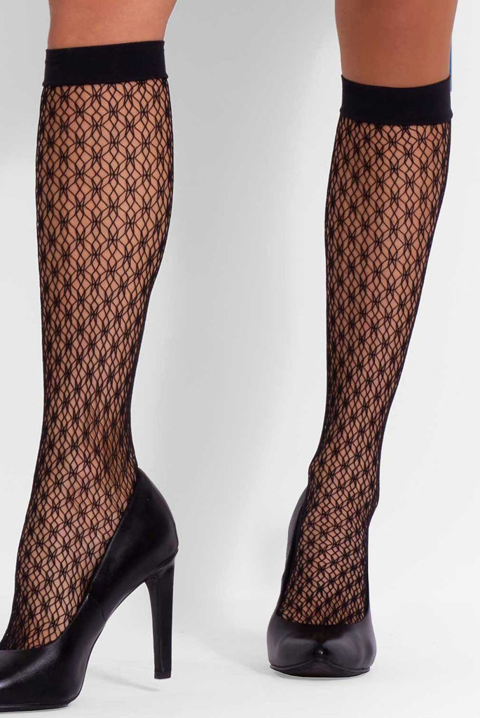 Close up of lady's lower legs in black pattern knee highs.