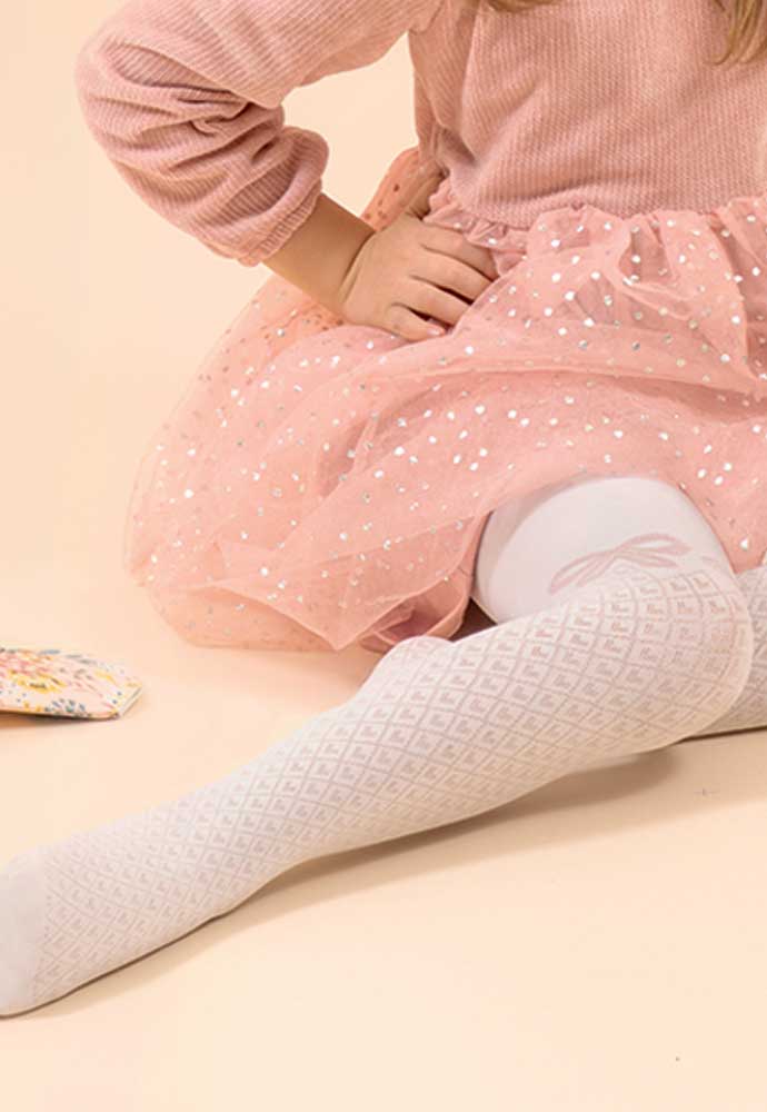 Close up of young girls' lower leg showing diamond and heart pattern tights.