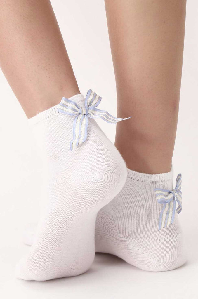 Back of lady's feet in white ankle socks adorned with blue striped bow.