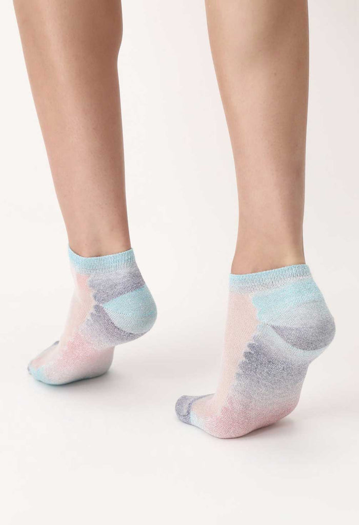 Back of lady's feet wearing multicoloured sneaker socks.