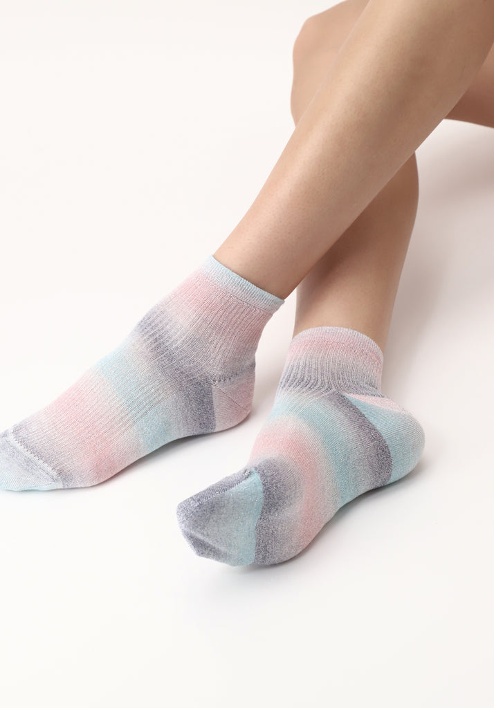 Lady's feet outstretched, wearing multicoloured ankle socks.