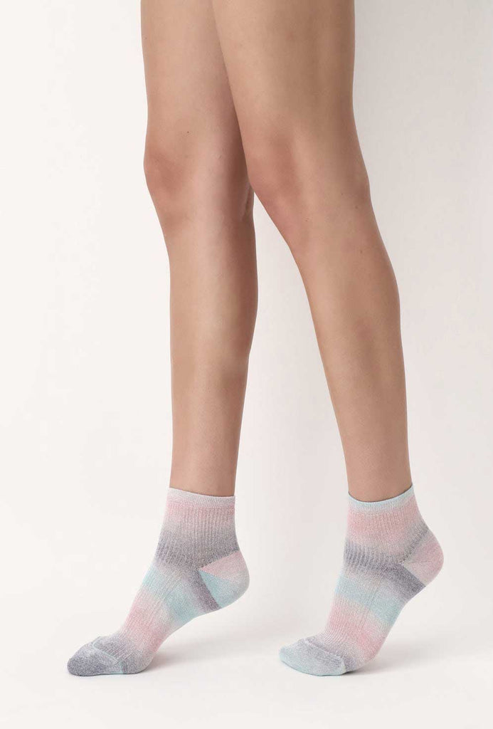 Lady's feet in walking stance and wearing multicoloured ankle socks.
