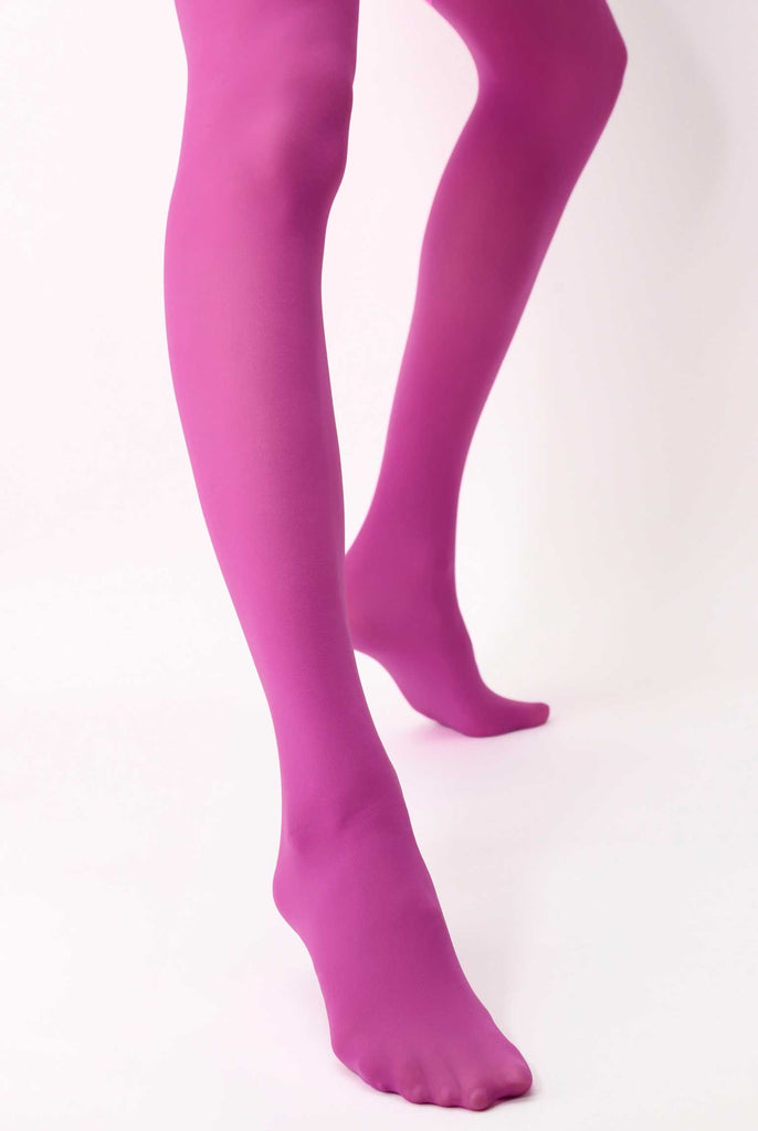 Lower legs of a lady, standing apart wearing dark lilac tights.