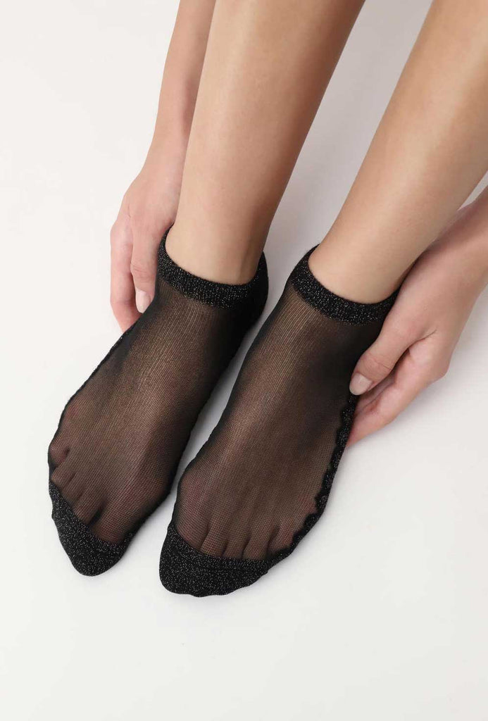 Lady's feet in black trainer socks.