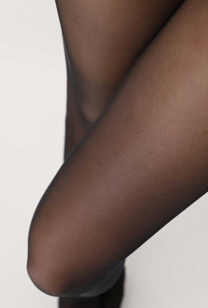 Close up of lady's thighs wearing black sheer tights.