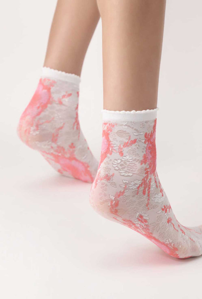 Side view of lady's feet in white and coral socks.