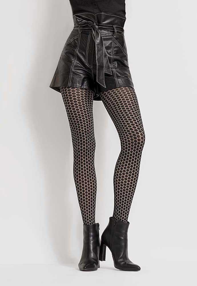 Front view of lady's lower body, wearing a black leather skirt, grey and black dot tights and black boots.