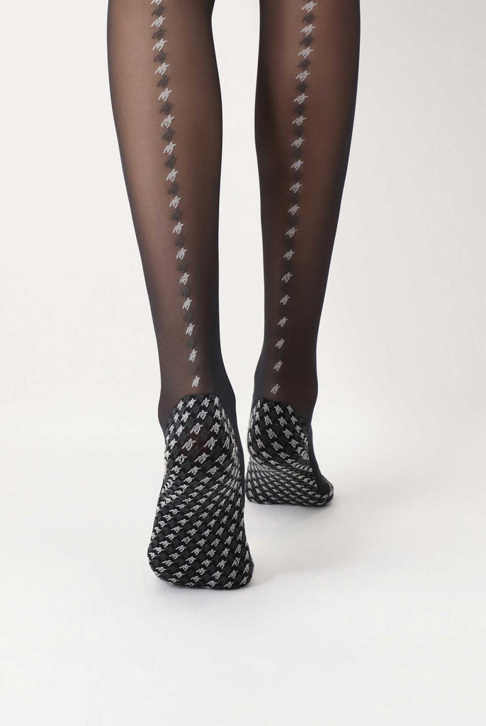 Back view of lady's lower legs, wearing pattern black sheer tights.