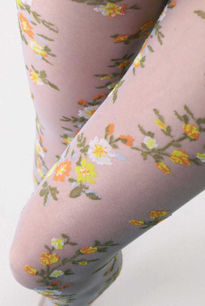 Close up of lady's upper tights in coloured, embroidery floral tights.