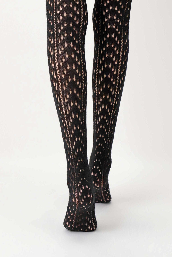 Close up of back view of lady's lower legs, wearing black, knit tights.