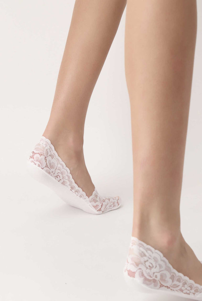 Back, side view of lady's feet in white lace sockettes.