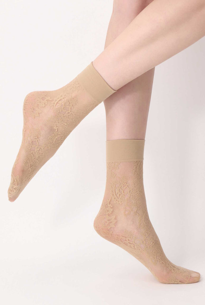 Side view of lady's feet wearing sheer, lace nude ankle socks.