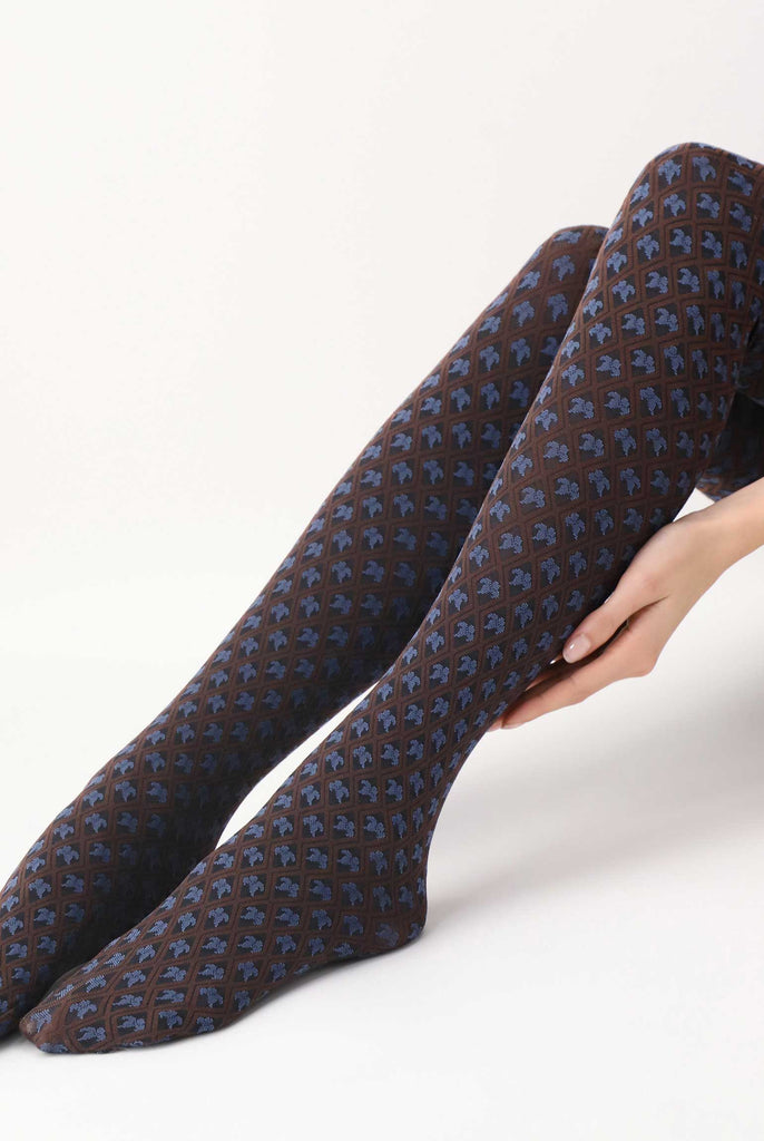 Lady's lower legs outstretched, wearing brown and blue motif pattern tights.