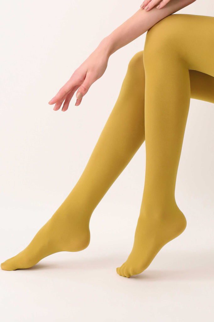 Lady's lower legs in mustard yellow tights, slightly extended with her hand resting on her knee