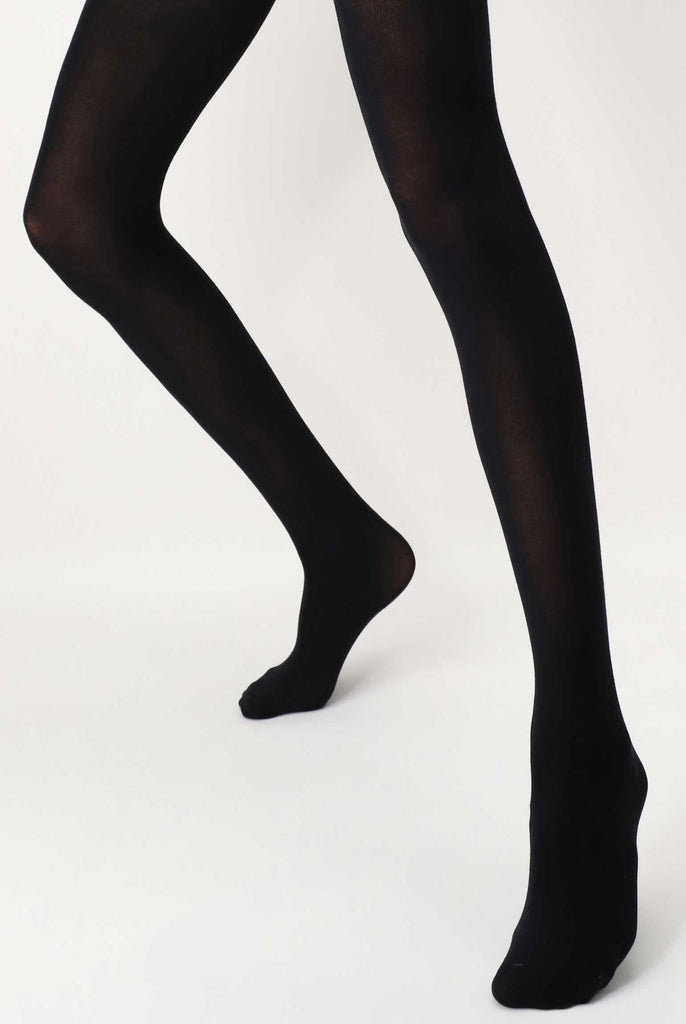 Front view of lady's legs lower legs, standing apart in black tights.