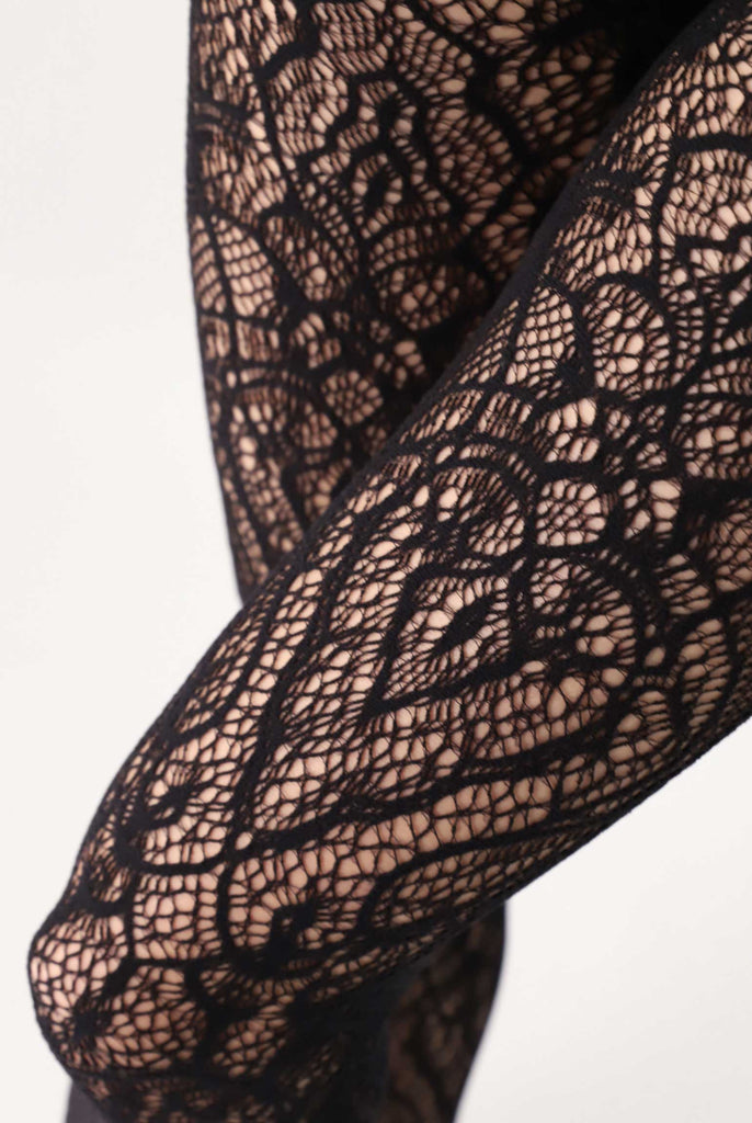 Close up of lady's thighs, wearing black lace net tights.