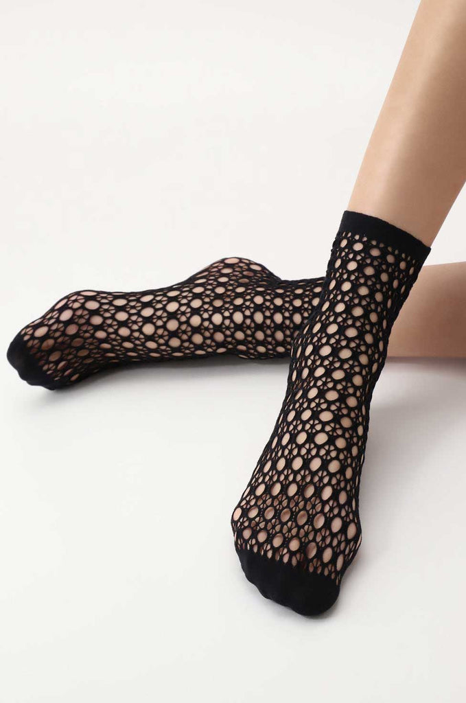 Close up of a woman's feet wearing black mesh patterned socks.