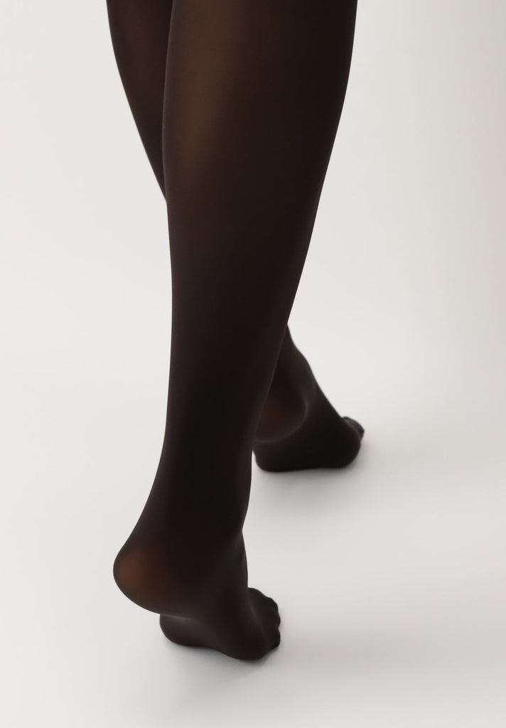 Back view of lady's lower legs, wearing brown tights.