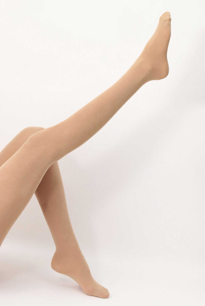 Side view of lady's legs, one kicking upwards and wearing camel coloured tights.