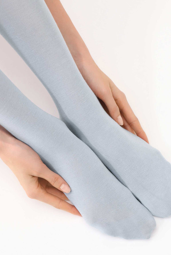 Close up of lady's feet wearing crystal blue tights.