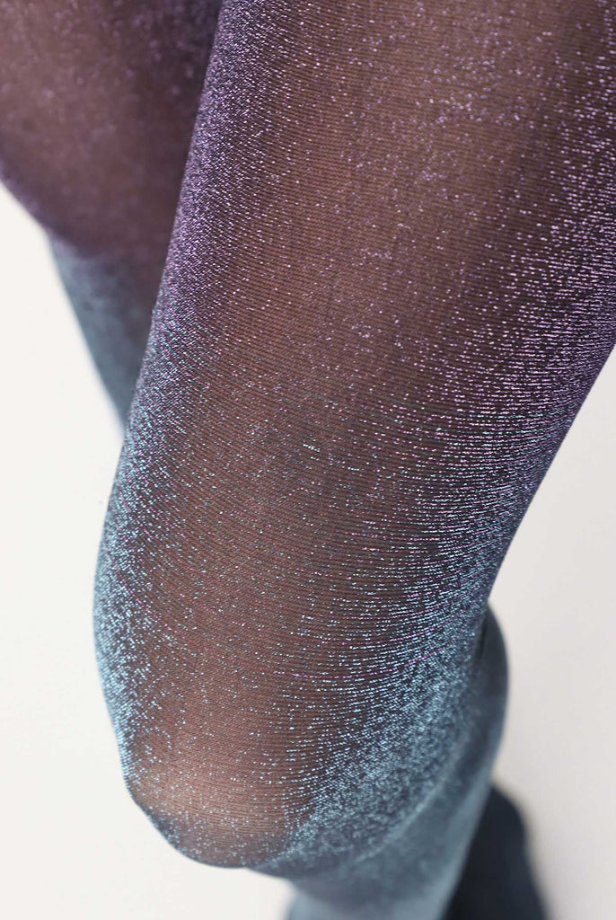 Close up of upper thigh and knee cap of lady's leg in sparkly purple tights.