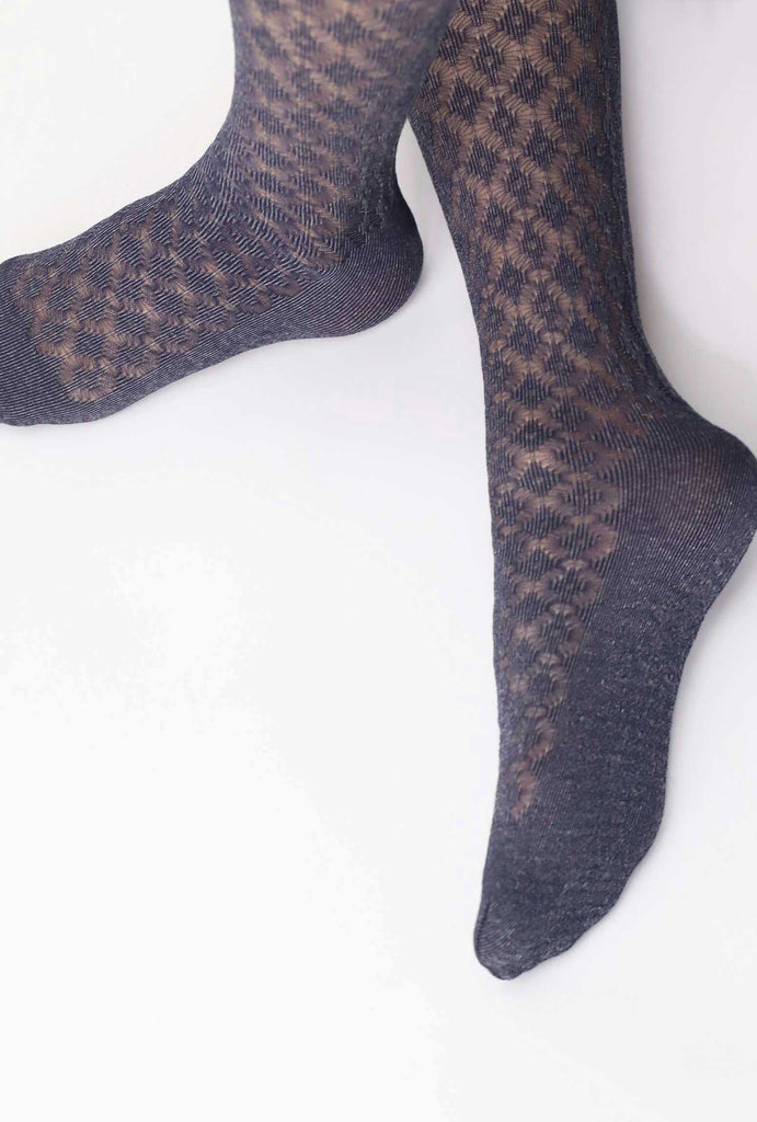 Close up fo lady's feet, crossed over and wearing blue patterned tights in with a reinforced sole.