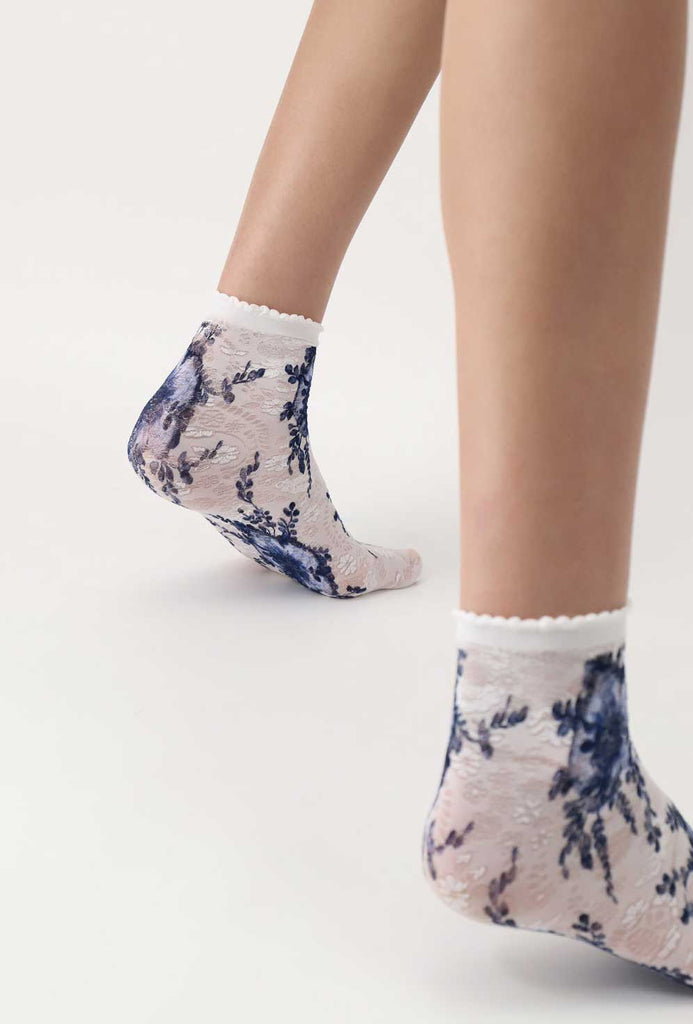 Back view of lady's feet in white and blue floral socks.