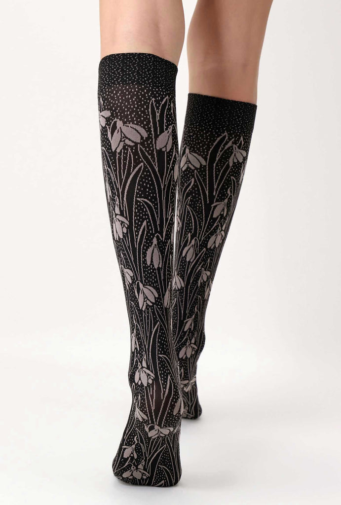 Back view of lady's legs in black and beige floral knee highs.