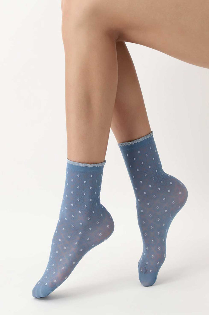 Close up of lady's feet wearing light blue patterned ankle socks.