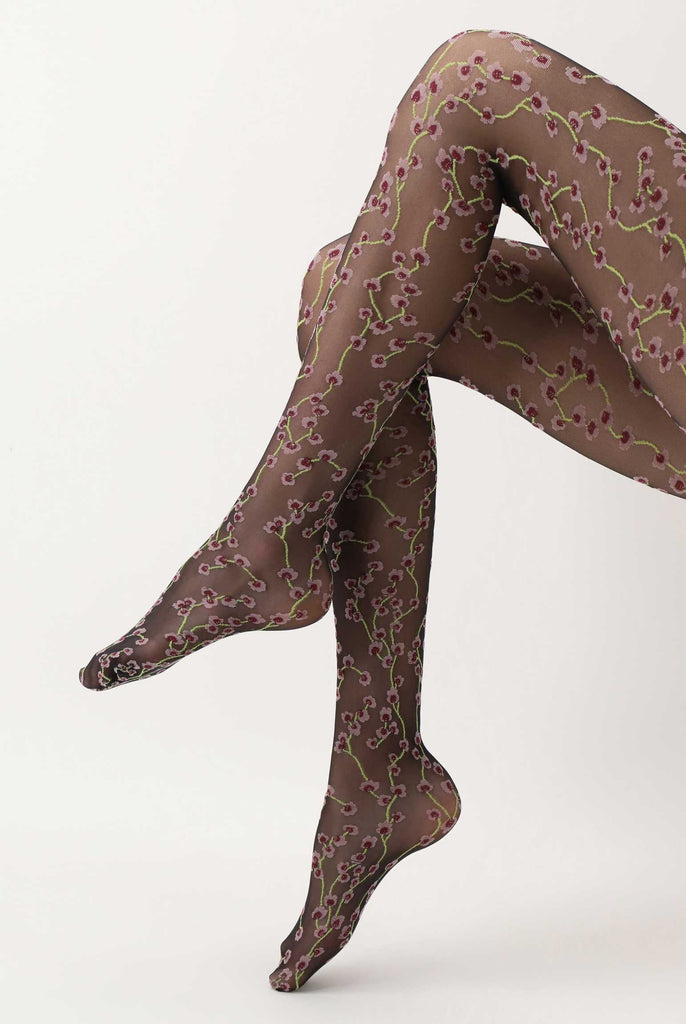 Side view of lady's lower legs uplifted, wearing black sheer floral tights.