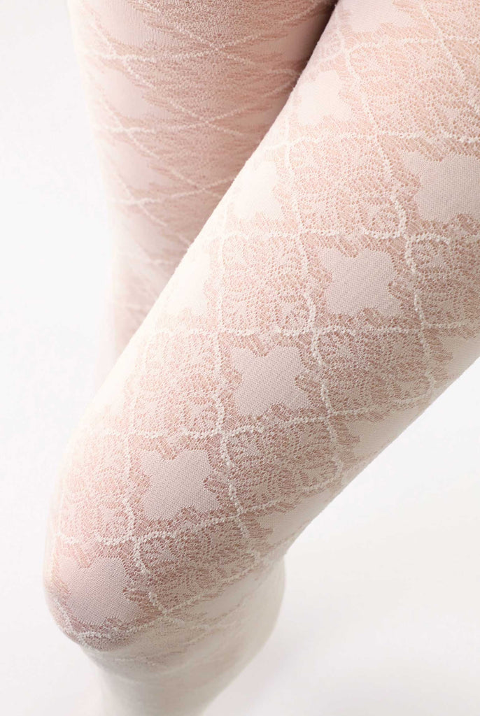 Close up of lady's upper thighs wearing cream coloured patterned tights.