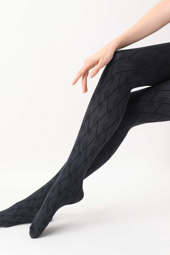 Lady's lower legs, crossed and stretched, wearing grey and black jacquard tights.