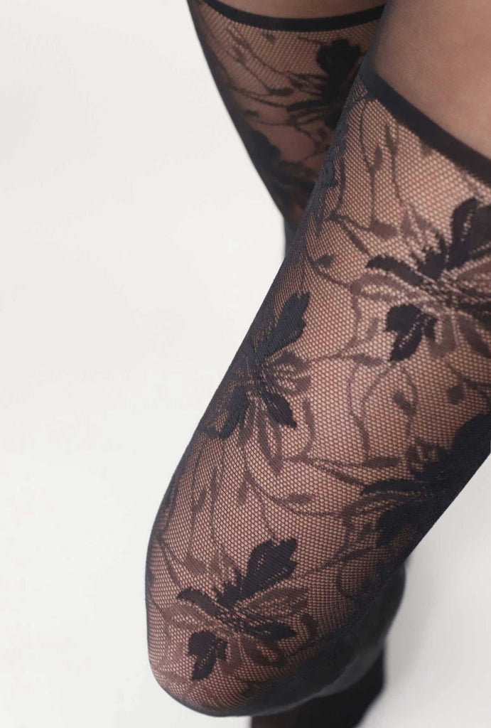 Close up of lady's upper thighs, wearing black lace tights.
