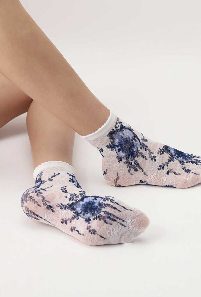 Lady's feet wearing white and blue flower socks.