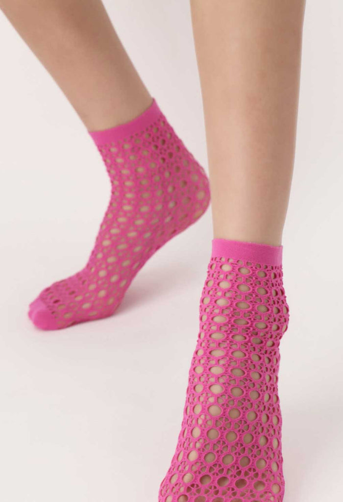 Close up of a woman's feet wearing, pink coloured, mesh socks.