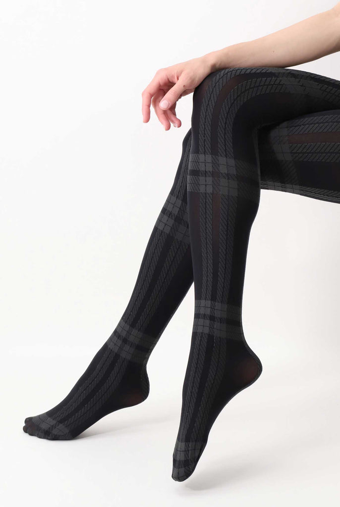 Side view of lady's lower legs in a sitting crossed position, wearing grey check tights.