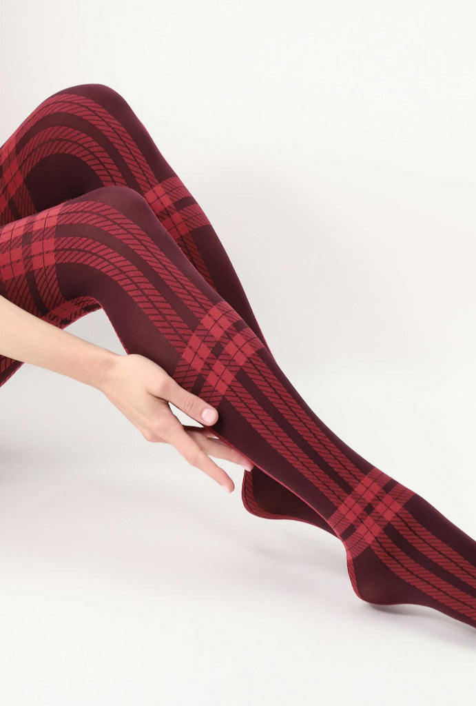 Lady's lower legs outstretched, wearing red tartan tights. 