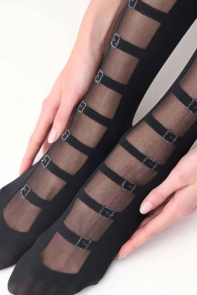 Close up lady's feet in black sheer striped buckle pattern tights.