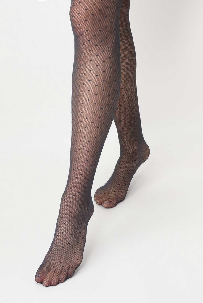 Front view of lady's legs, walking and wearing black polka dot sheer tights.