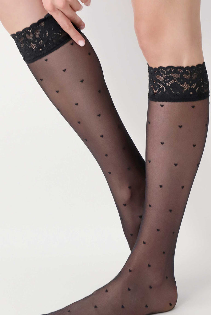 Side view of lady's lower legs in sheer black pattern knee high socks.