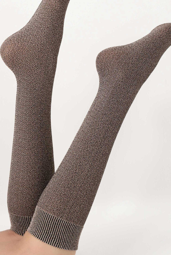 Back view of lady's lower legs kicking up in the air, wearing brown tweed socks.