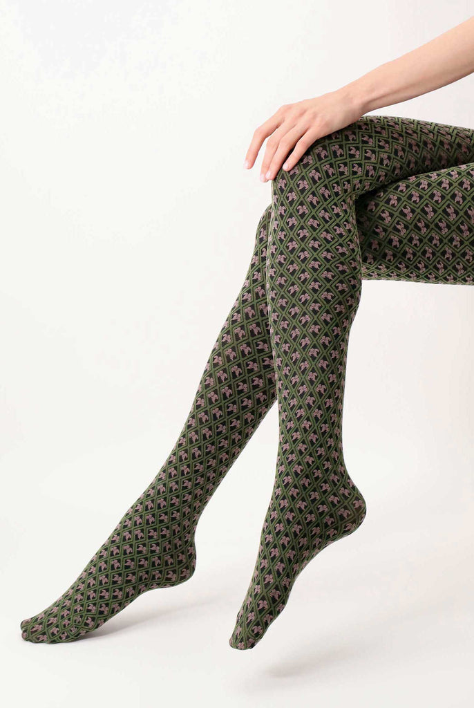 Side view of lady's lower legs crossed and wearing green and peony motif coloured tights.